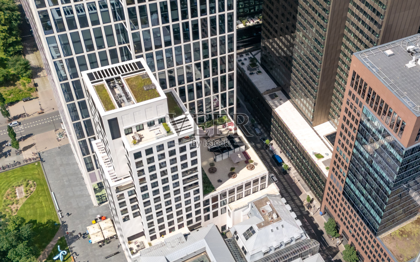 在一个阳光明媚的日子里，城市中心的现代办公大楼和绿地的鸟瞰图。照片摄影图片