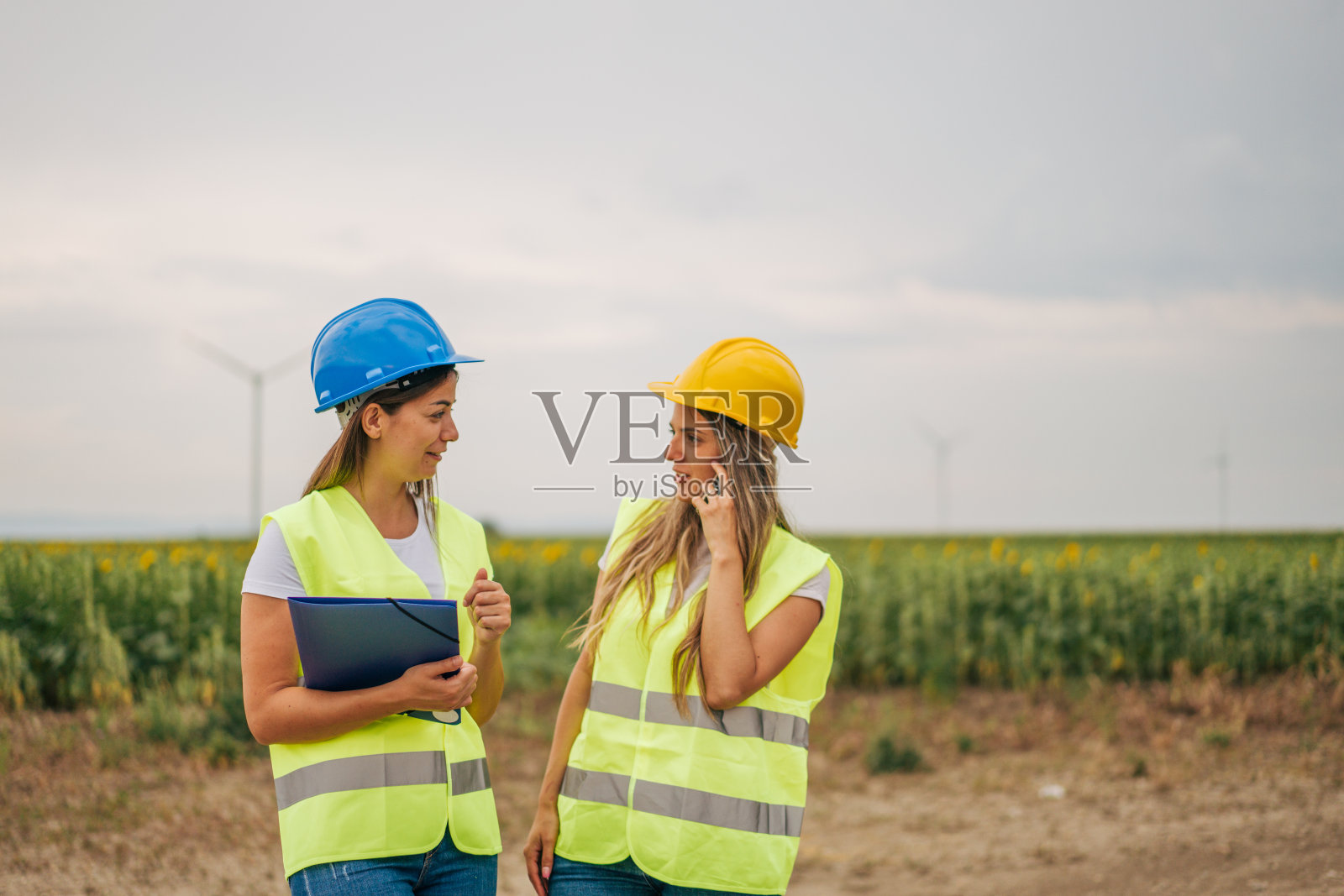 两位女工程师，风车为可再生能源、电力和电力创新。照片摄影图片