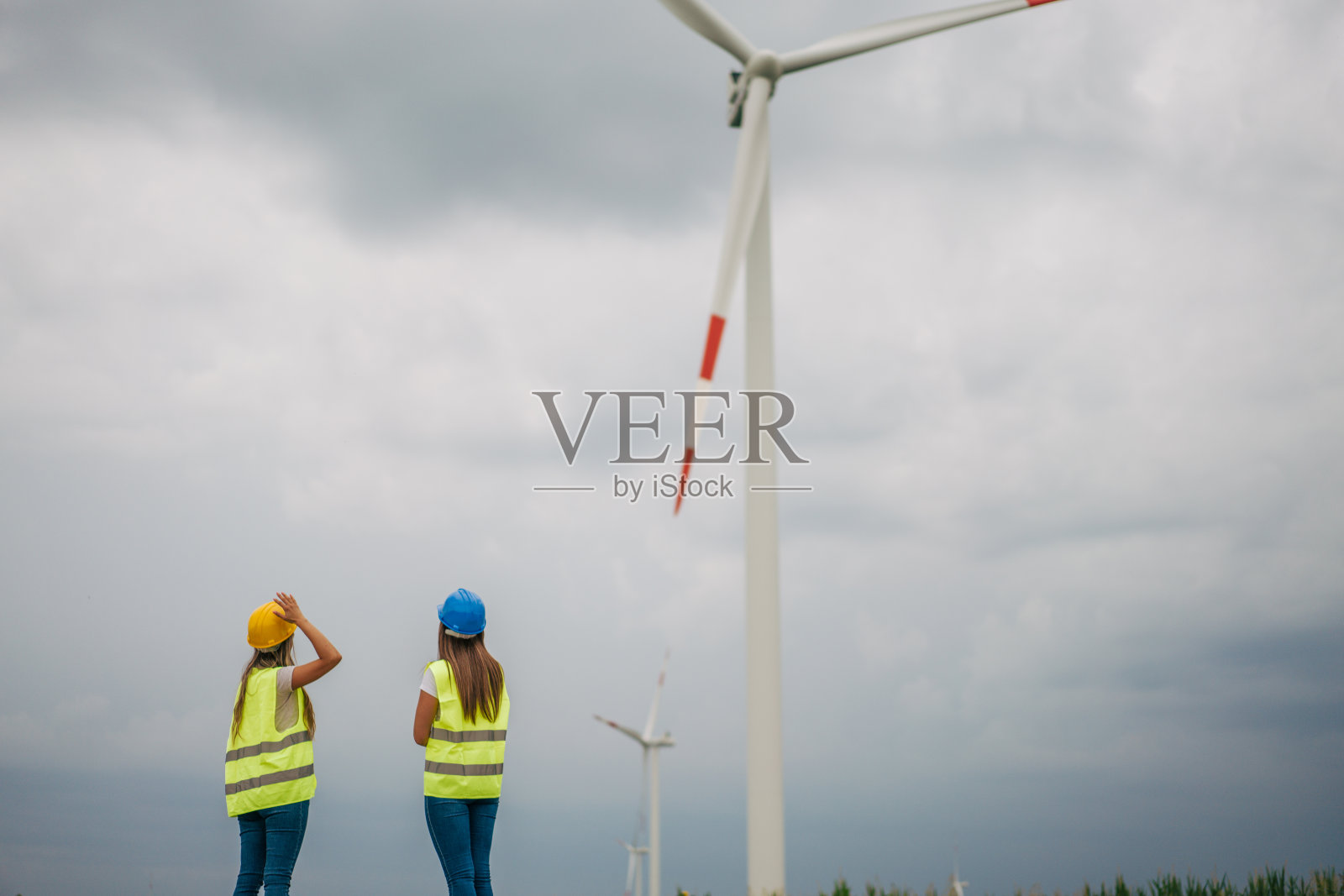 两位女工程师，风车为可再生能源、电力和电力创新。照片摄影图片