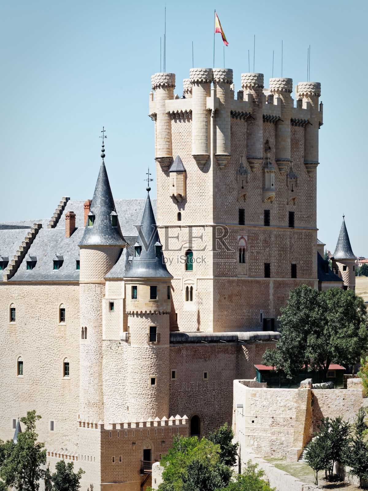 西班牙塞戈维亚，阳光明媚的一天，“塞戈维亚城堡”里有塔楼和一面西班牙国旗照片摄影图片