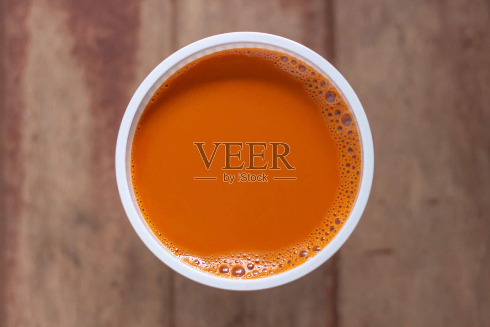 木桌上白色杯子里的热奶茶照片摄影图片