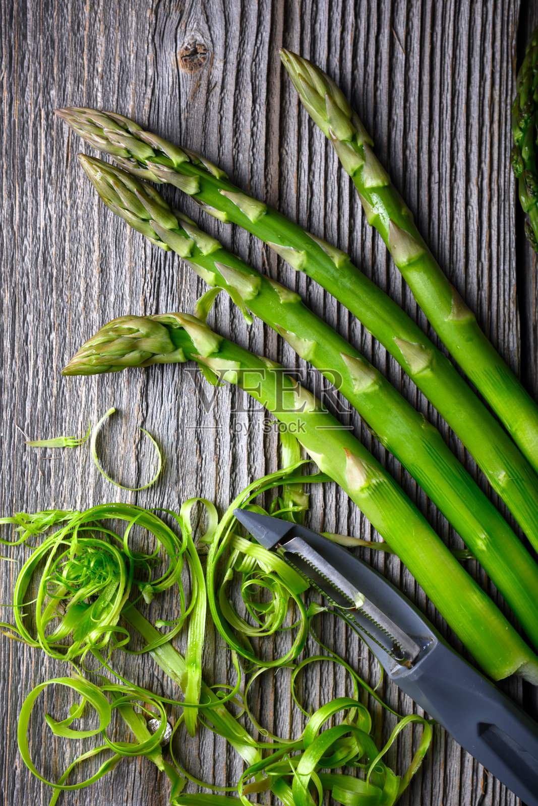 新鲜芦笋芽配蔬菜削皮器照片摄影图片