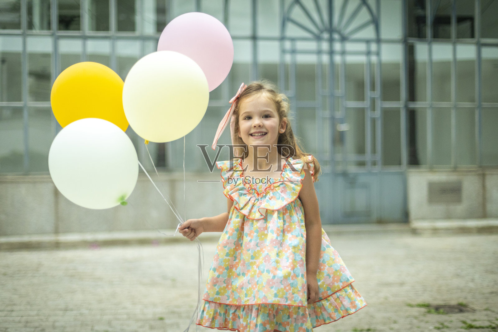 微笑的女孩在户外拿着五颜六色的气球。照片摄影图片