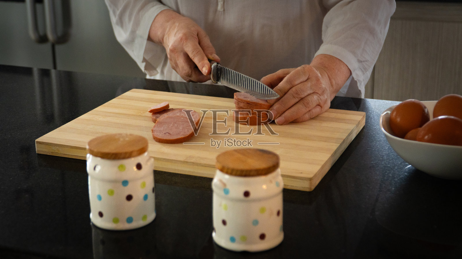 切香肠的老妇人照片摄影图片