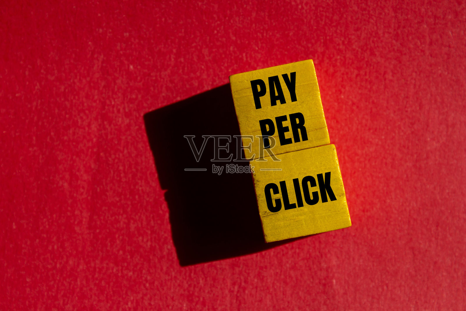 支付每点击信息写在黄色的木制立方体与红色背景照片摄影图片