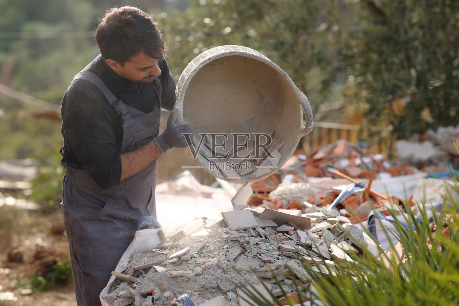 建筑工人正在清理手推车上的碎片照片摄影图片