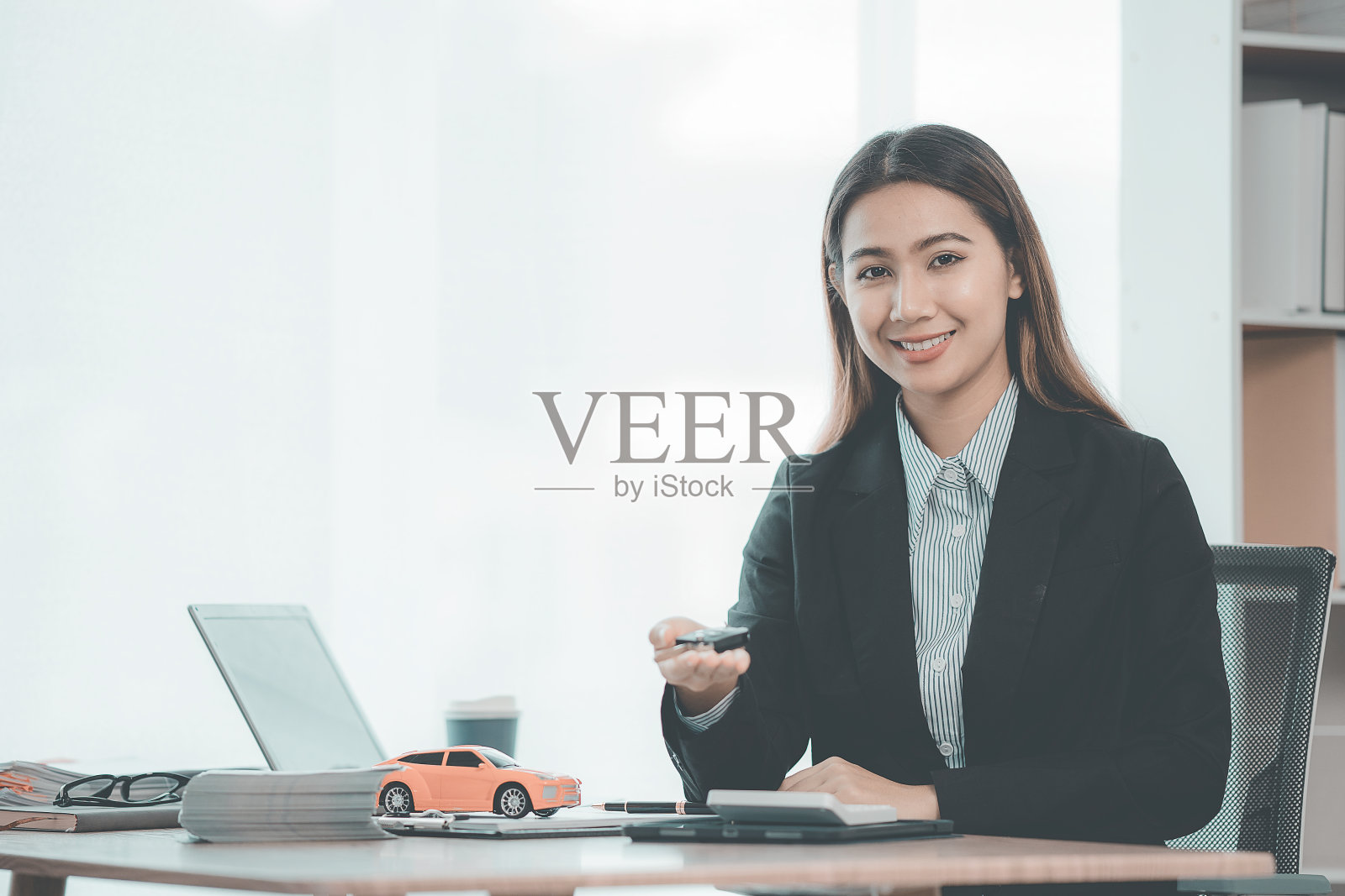 销售顾问，拿着剪贴板指导客户的年轻女孩，汽车经销商，给客户或买家提供建议的销售人员。展示现代租车、试驾服务。照片摄影图片