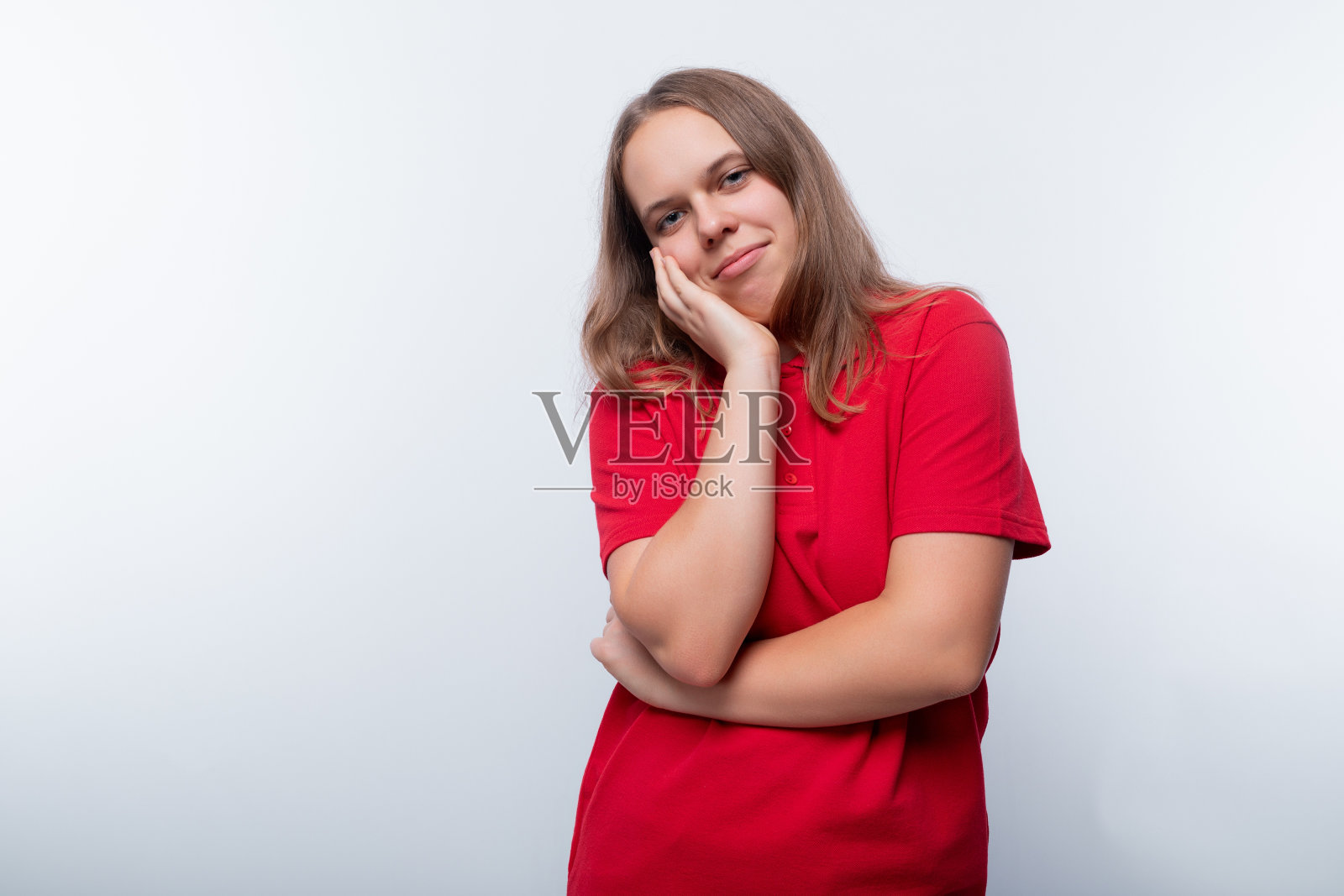 一个谦虚的少女把脸藏在白底上照片摄影图片