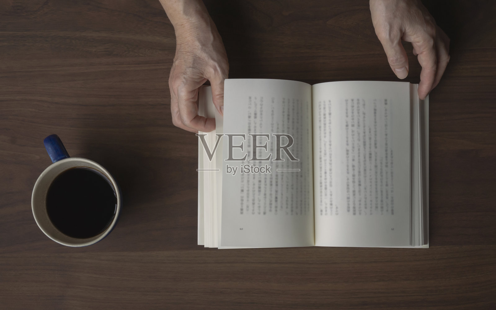 在读一本书的高年级女生。照片摄影图片