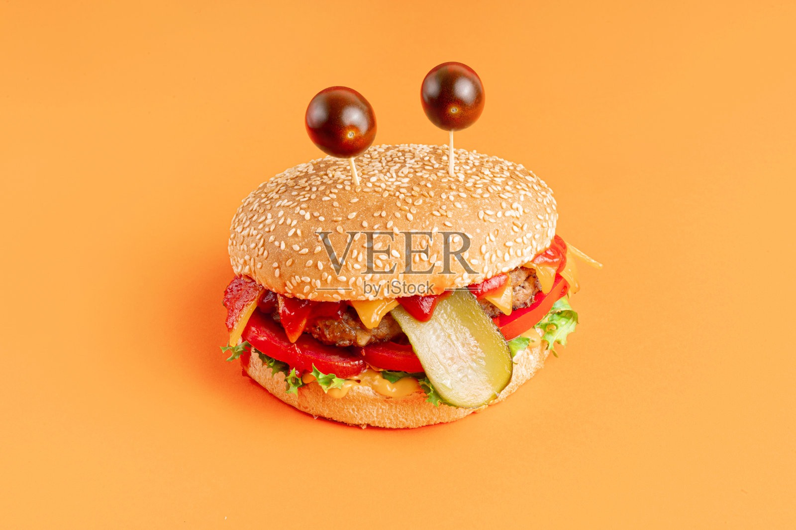 橙色背景上的搞笑怪物汉堡照片摄影图片