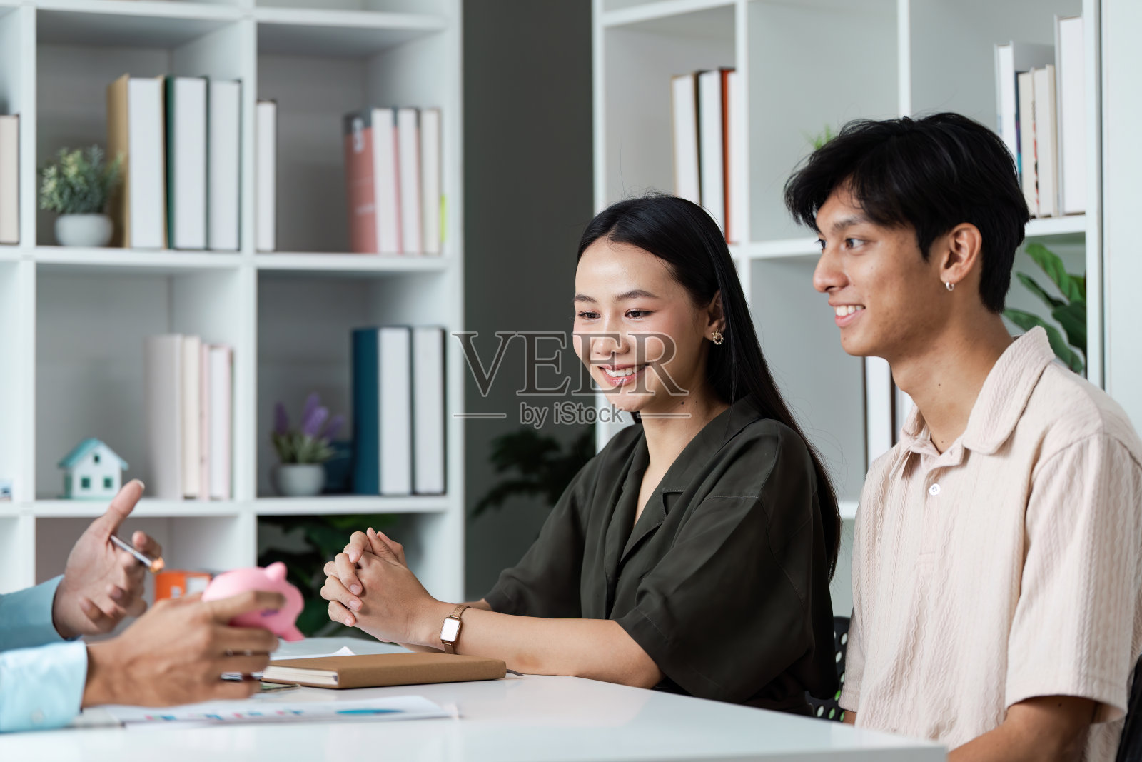 年轻夫妇在现代办公环境下与专业顾问讨论理财计划投资照片摄影图片