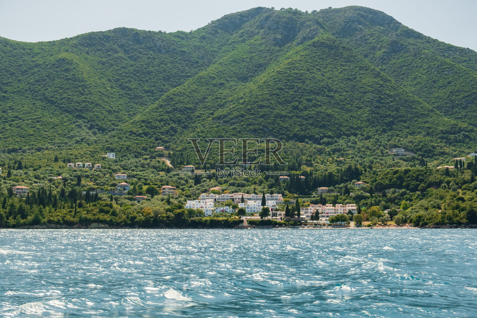 看游艇小海滨度假小镇在希腊的山脉上的岛屿上的海岸线在公海。蓝色的大海俯瞰海岸岛屿。色雷斯人的海洋。旅游业。旅游的概念照片摄影图片