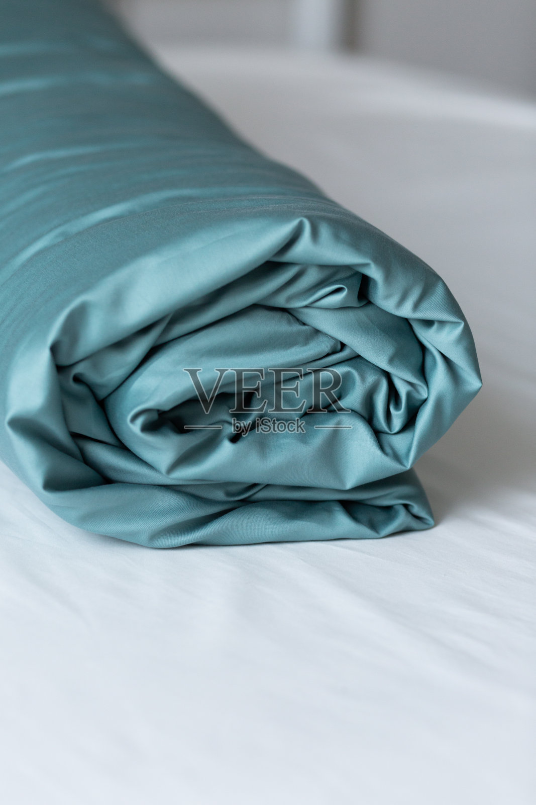 绿松石缎面羽绒被，床上有纽扣:莱赛尔，丝绸或聚酯。家纺。关闭了。背景。照片摄影图片