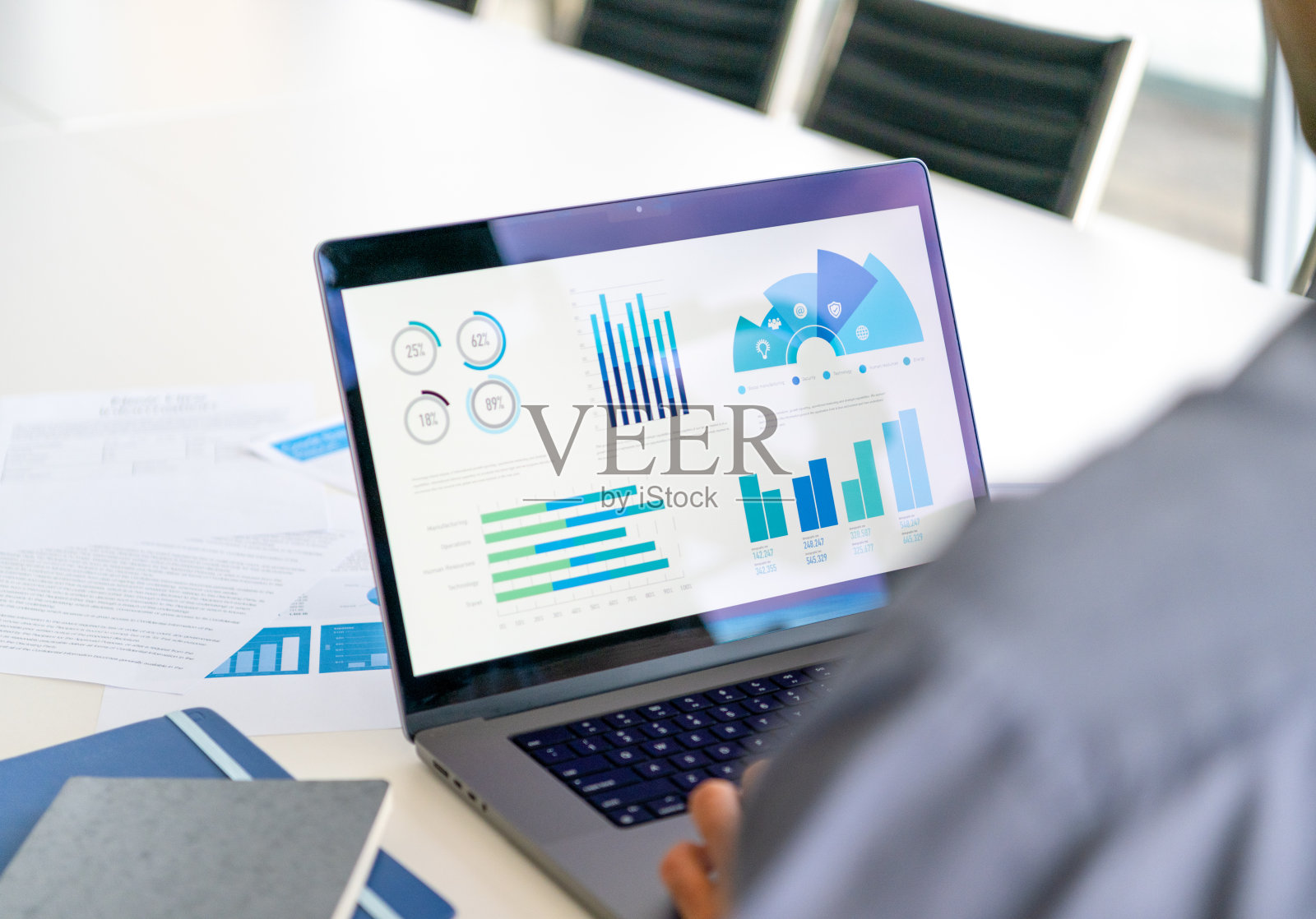 商人使用笔记本电脑的特写，笔记本电脑上有图形和图表。照片摄影图片