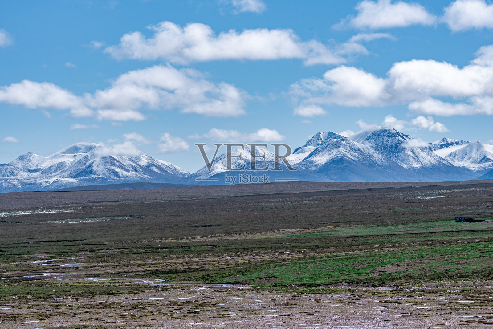 多云的天气，雪山和高原上的草地照片摄影图片