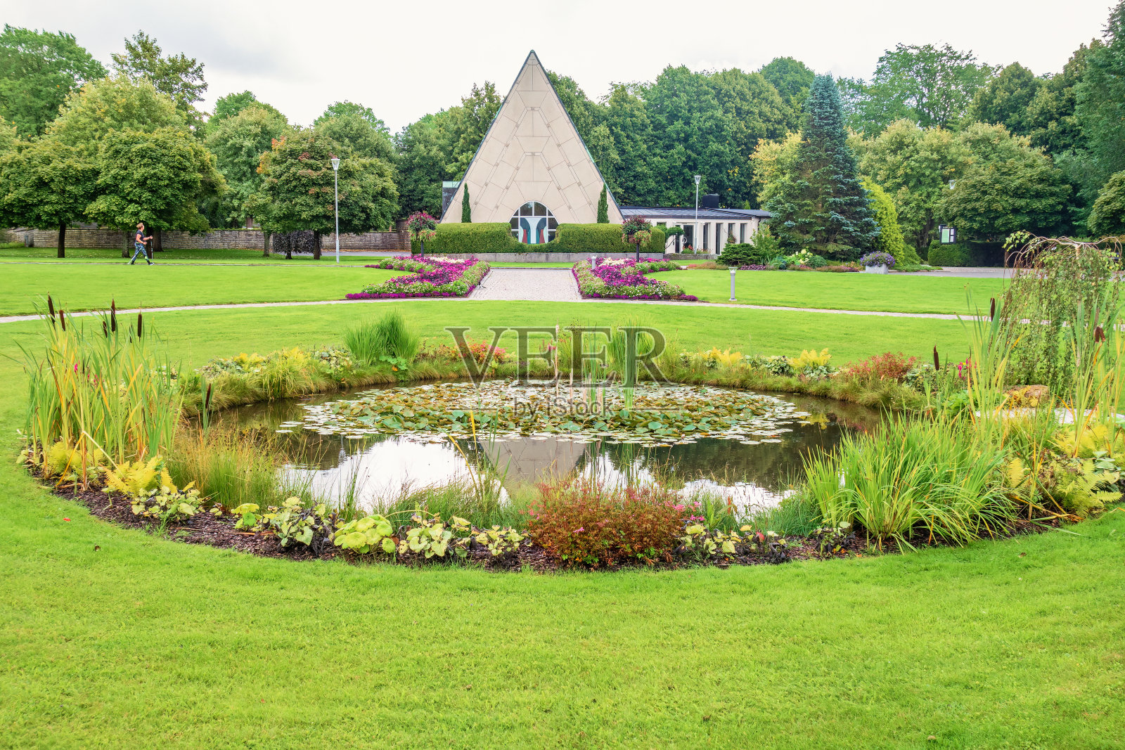 小教堂的池塘里有鲜花和绿色植物照片摄影图片