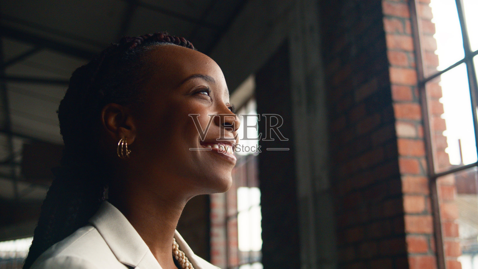 一个微笑的女人在现代工业环境与自然光的肖像照片摄影图片