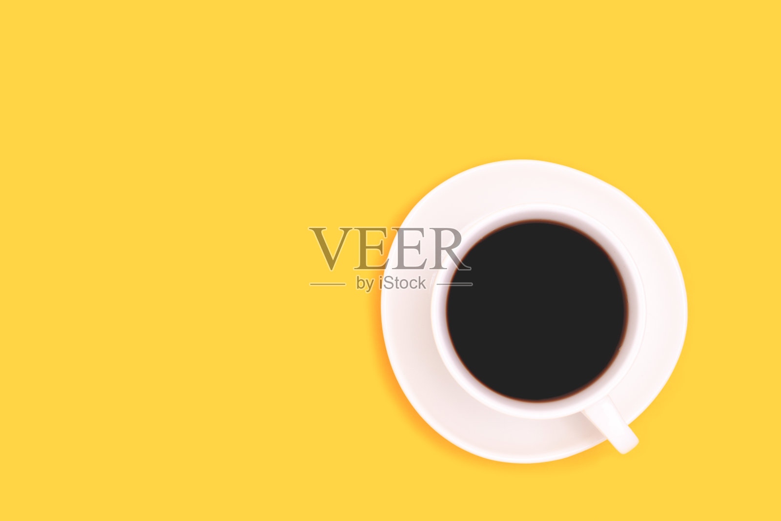 一杯黄底黑咖啡。照片摄影图片