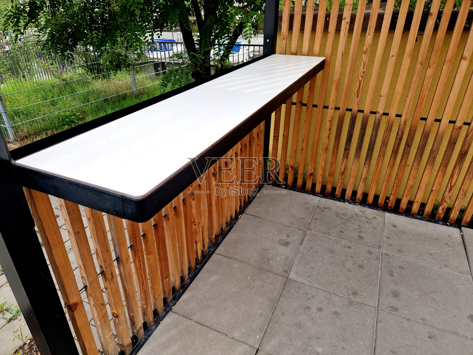 现代市场摊位由金属藤架结构组成，墙壁两侧有板条。公共汽车站吸烟亭的条纹外观照片摄影图片