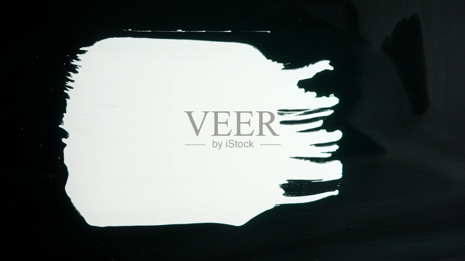 玻璃表面出现白漆条纹。在黑色孤立的背景上用白色丙烯酸颜料绘制。单色艺术绘画，极简主义照片摄影图片