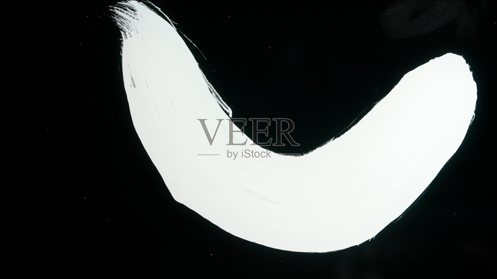 玻璃表面出现白漆条纹。在黑色孤立的背景上用白色丙烯酸颜料绘制。单色艺术绘画，极简主义照片摄影图片