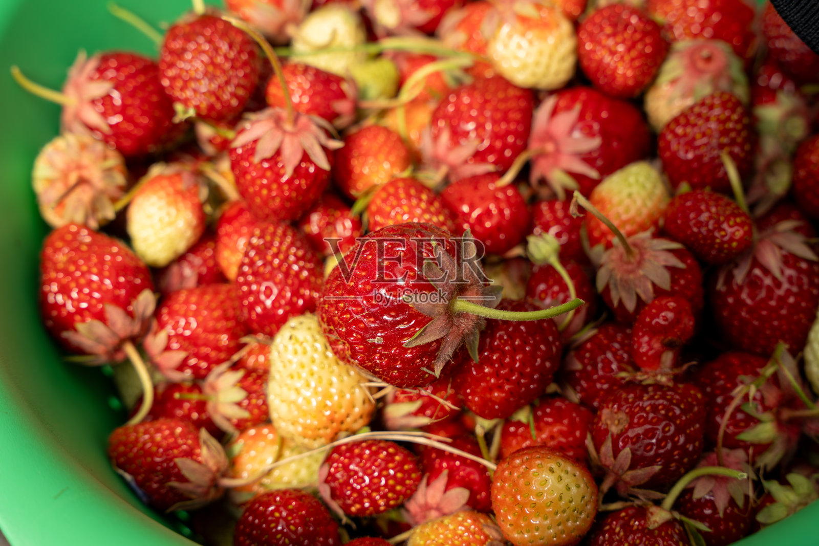 一碗草莓，有些是红色的，有些是黄色的照片摄影图片