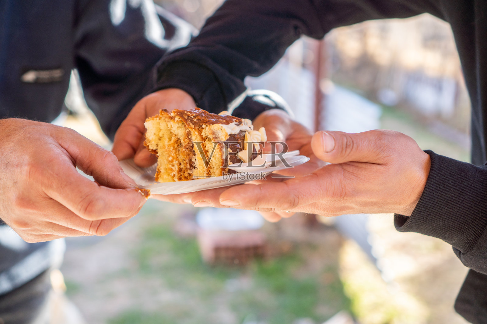 在日光下分享一块蛋糕，双手分享一块蛋糕照片摄影图片