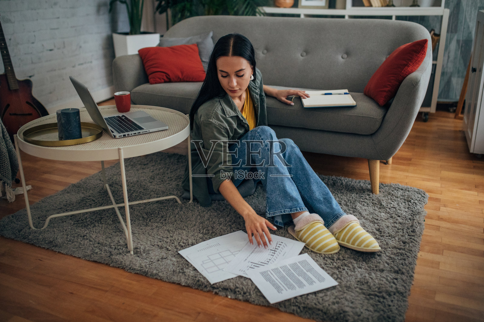 坐下时拾起散落文件的人。照片摄影图片