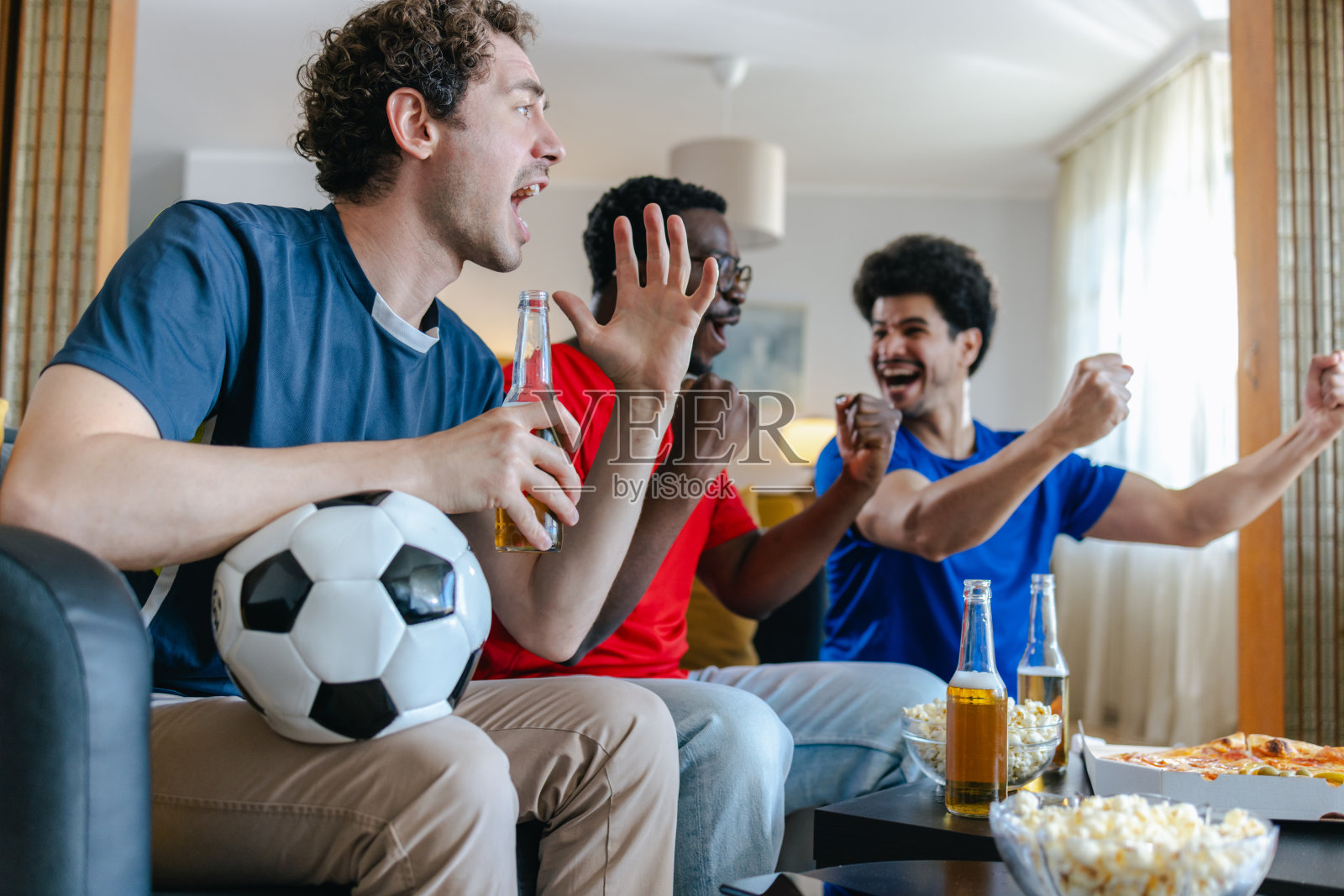 一群年轻男子在家观看体育比赛照片摄影图片