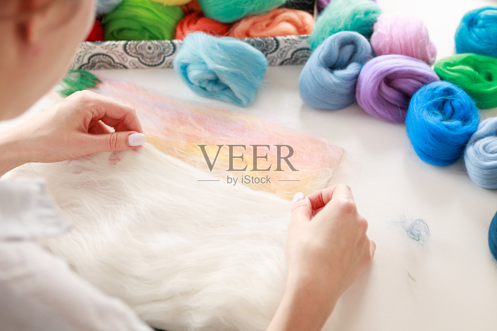 一个女孩正从事用羊毛制作手工物品，制作毛画，手工编织，选择性专注照片摄影图片