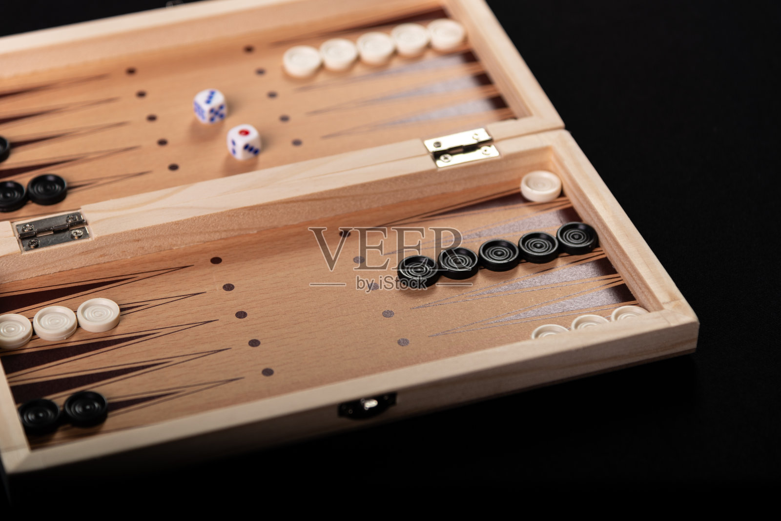 在黑色背景上玩双陆棋棋子和骰子的棋盘。照片摄影图片