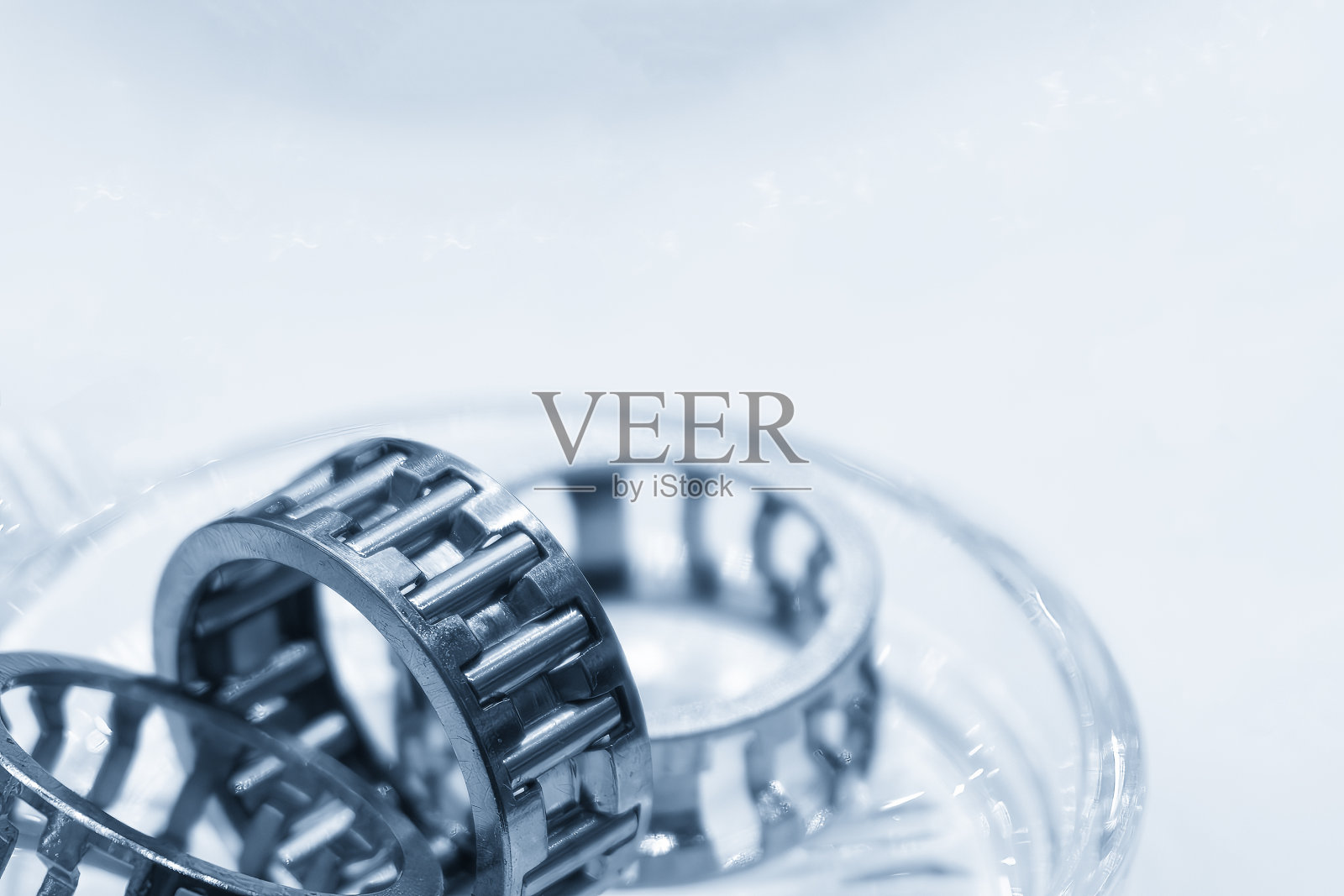 特写场景中滚针轴承部件在淡蓝色场景中。照片摄影图片