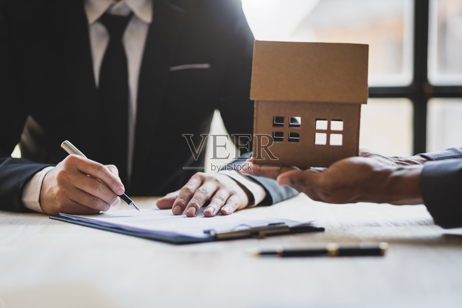 商人和房地产经纪人讨论签署合法购买房屋的文件。照片摄影图片