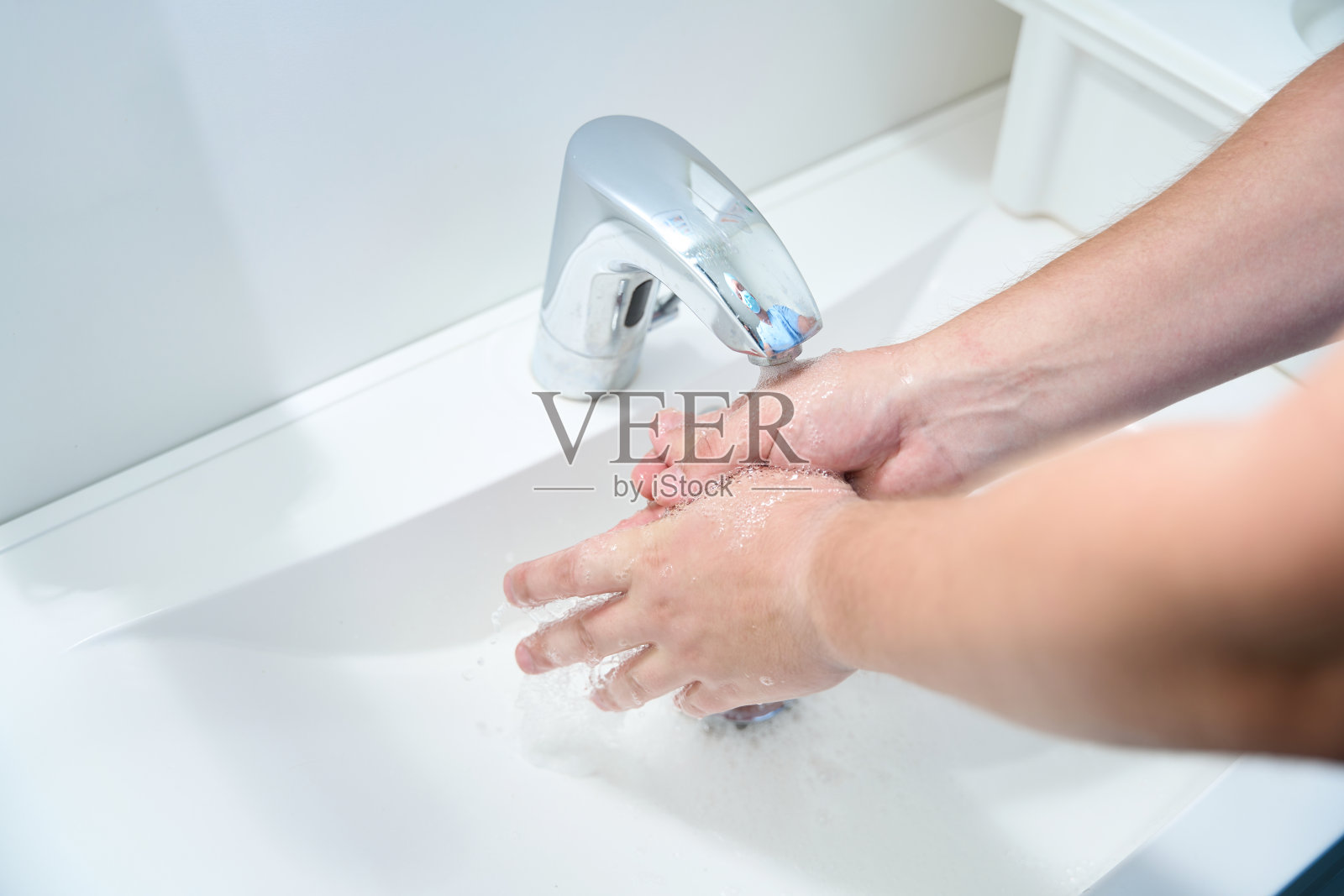 男医生用水洗手时在水池上的倒影照片摄影图片