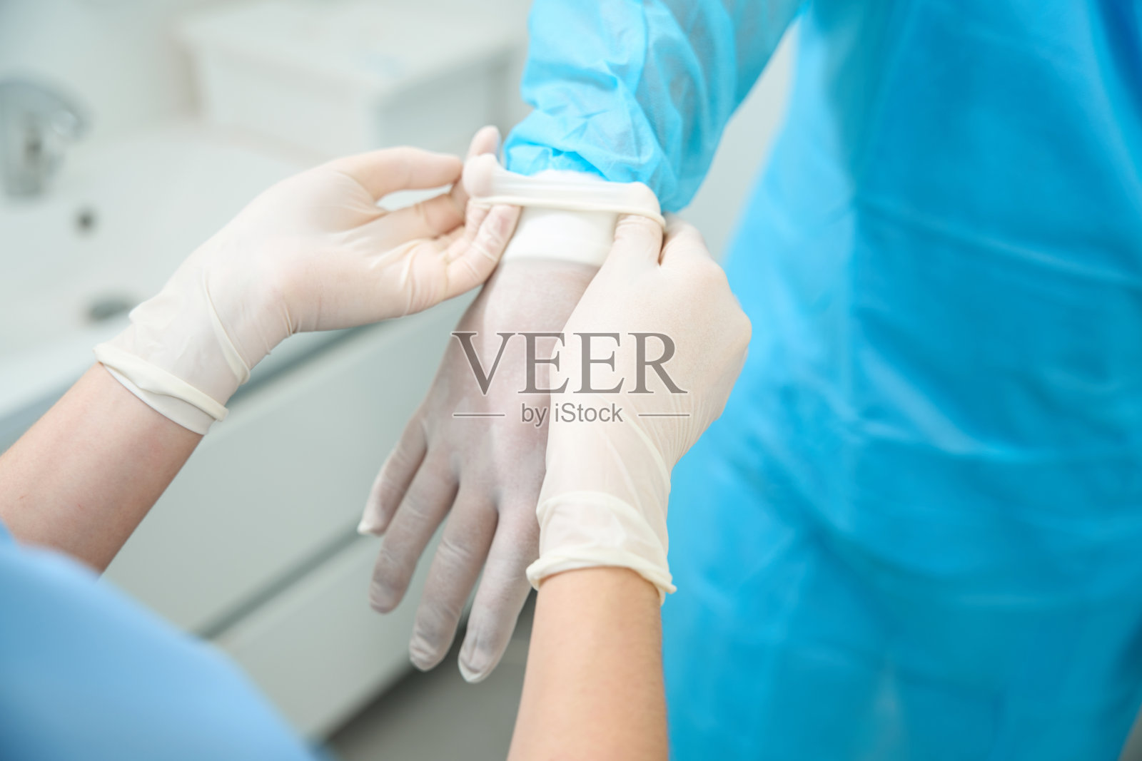 剪短的女护士帮助男医生戴上乳胶手套的图片照片摄影图片