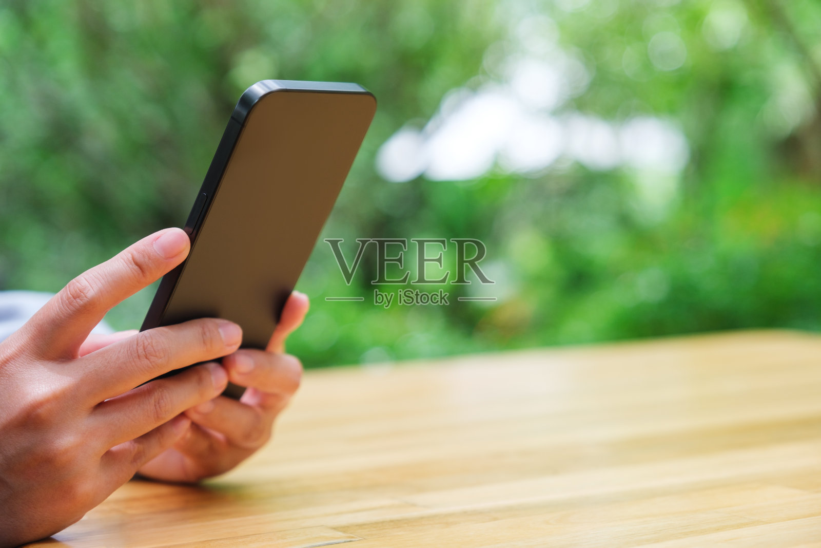 一名妇女在户外手持并使用手机的特写照片照片摄影图片