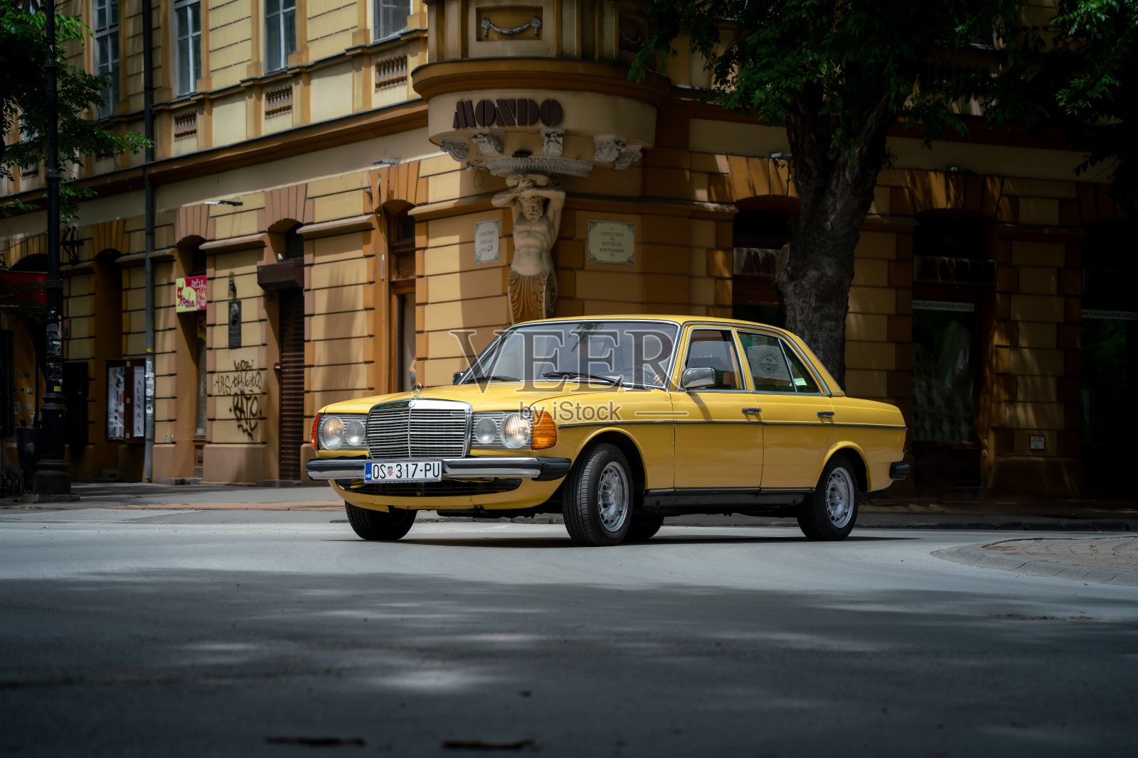 行驶着一辆黄色奔驰W123轿车照片摄影图片