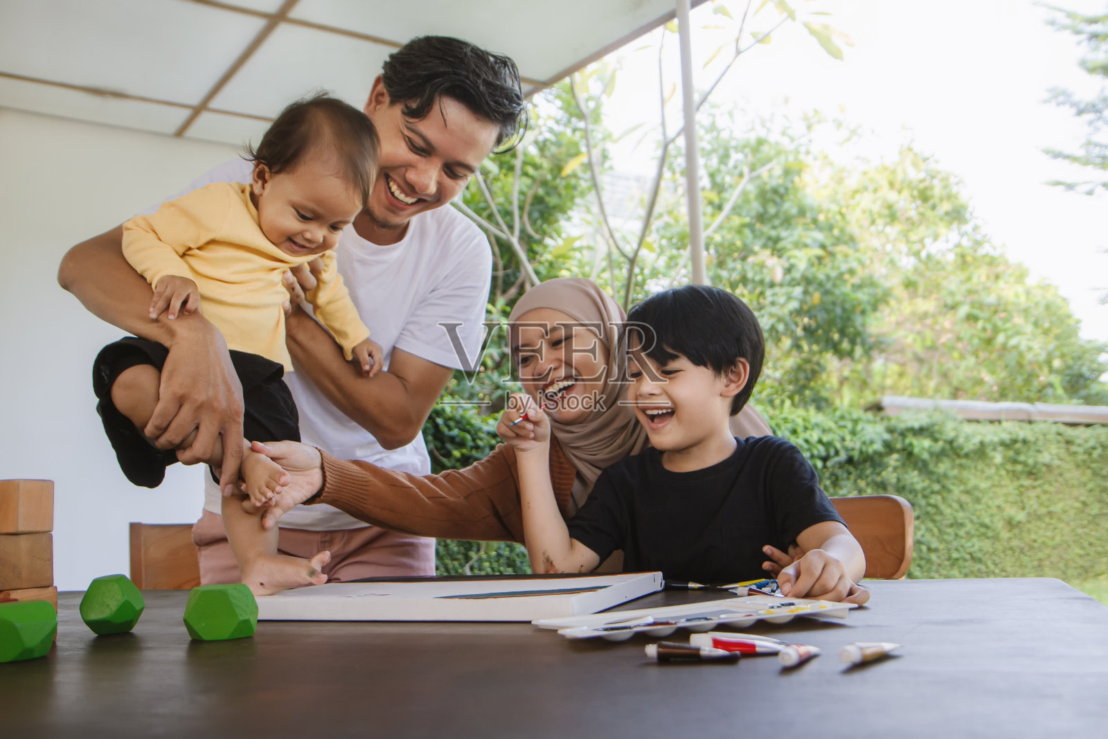 快乐的亚洲穆斯林家庭。父母教孩子手工制作和绘画照片摄影图片