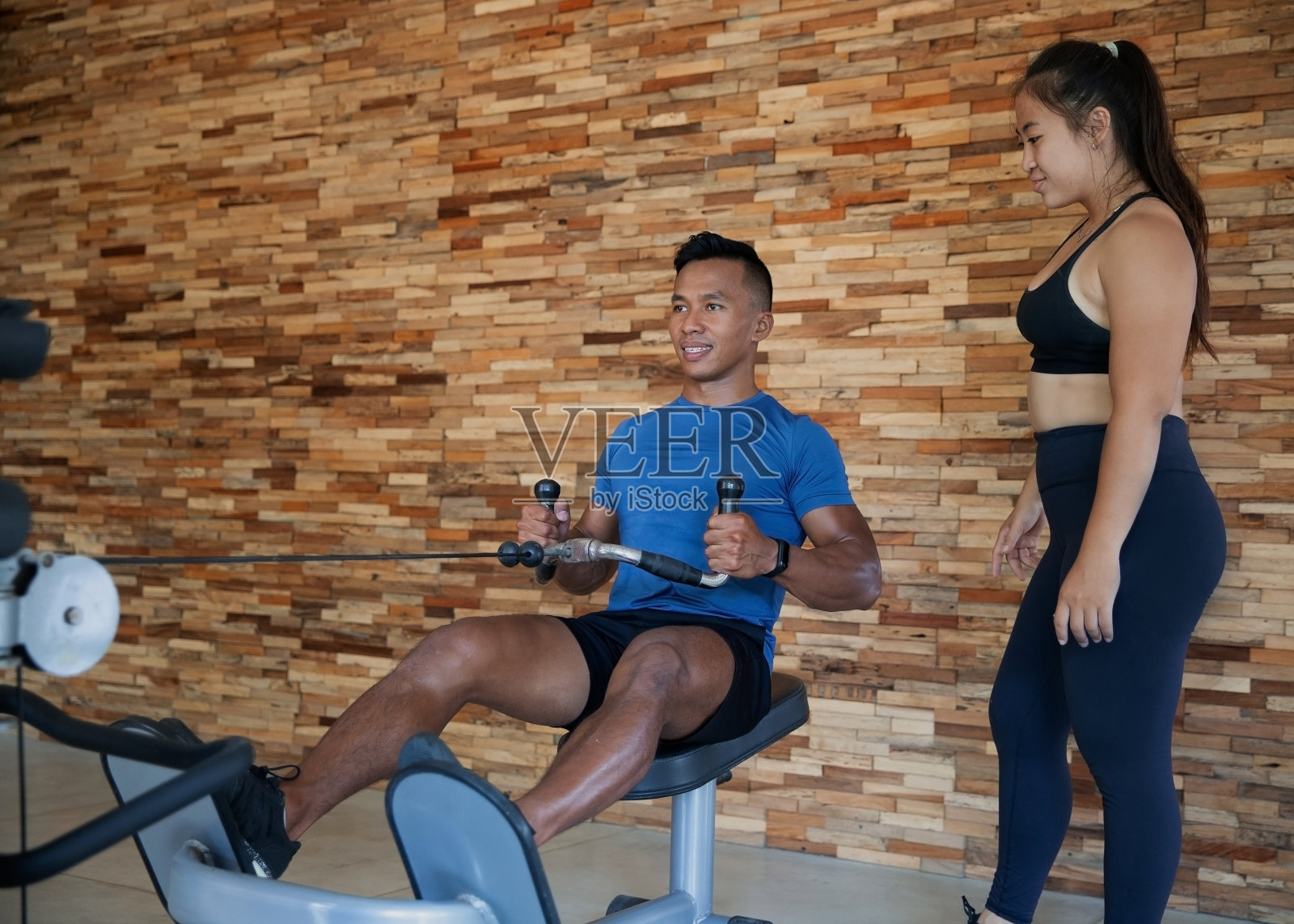 健身训练与私人教练在划船机上指导照片摄影图片