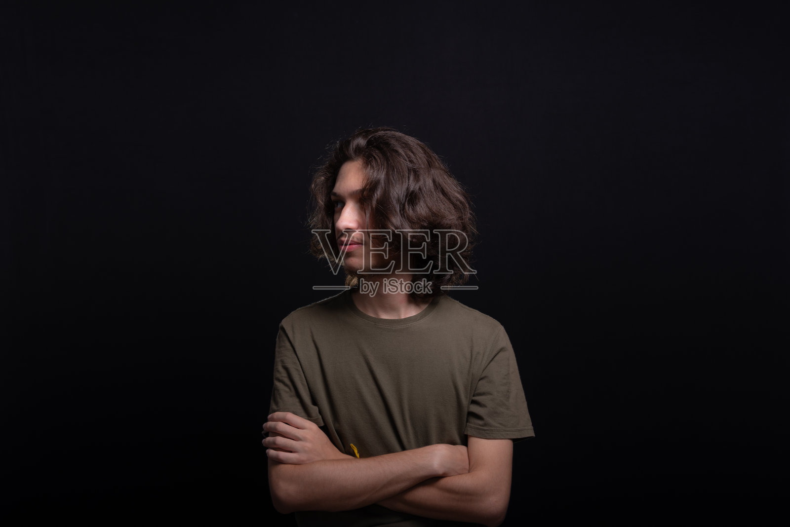 英俊的年轻男子的肖像，长头发和棕色的眼睛摆姿势拍照照片摄影图片