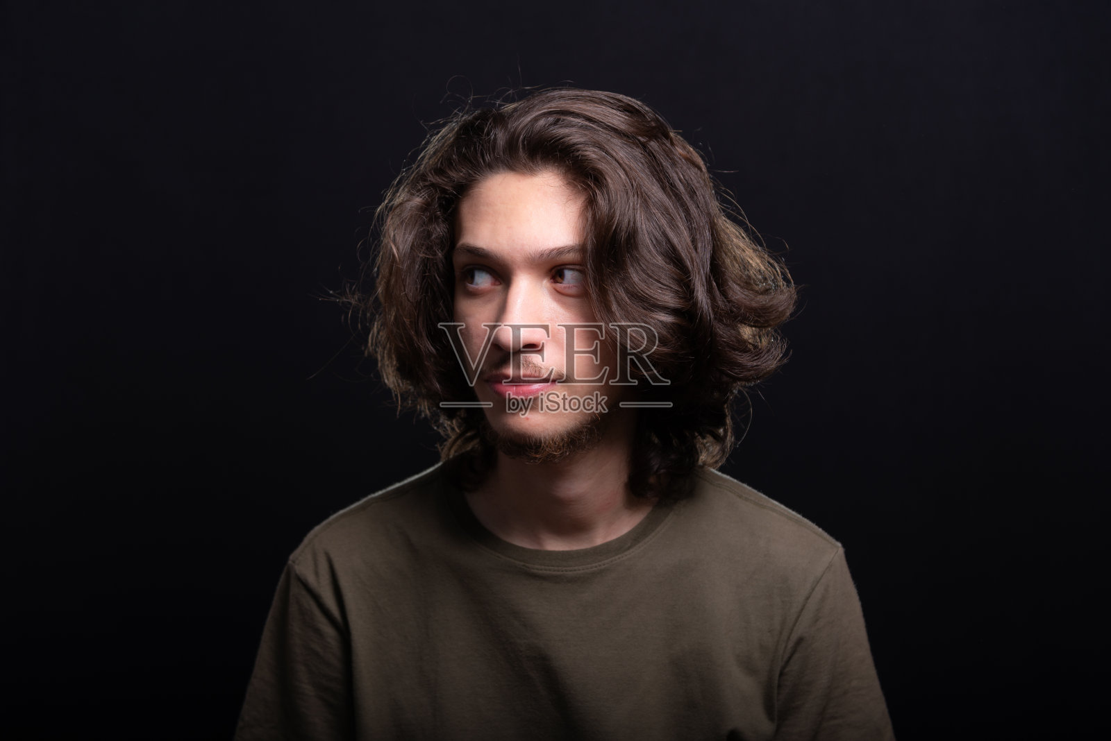 英俊的年轻男子的肖像，长头发和棕色的眼睛摆姿势拍照照片摄影图片