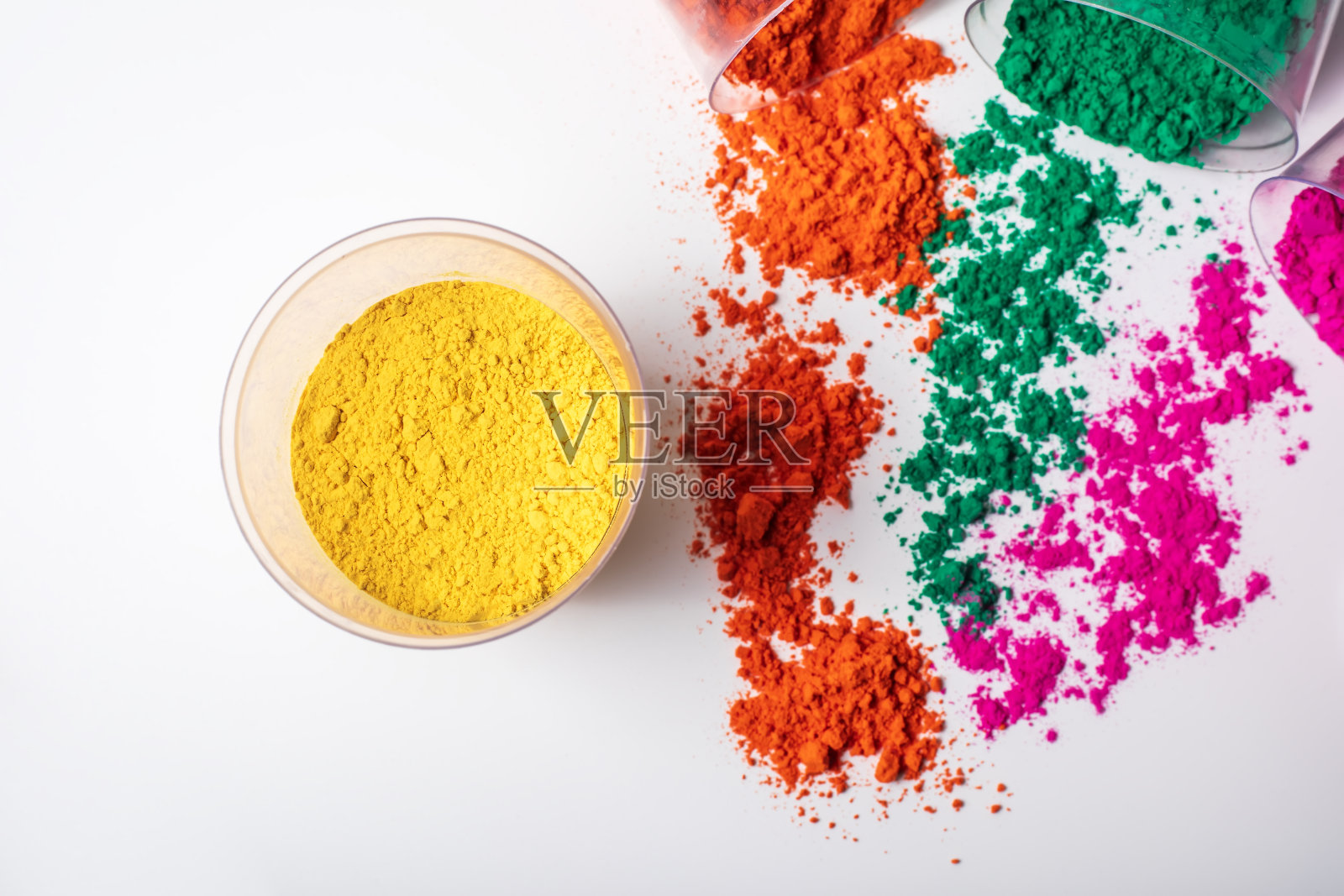 白色背景的玻璃碗里装着五颜六色的胡里粉。照片摄影图片