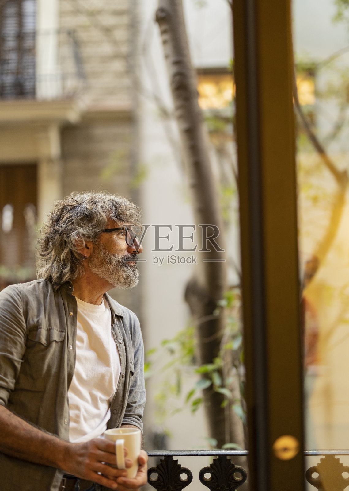 有思想的老人在阳台上拿着咖啡杯照片摄影图片