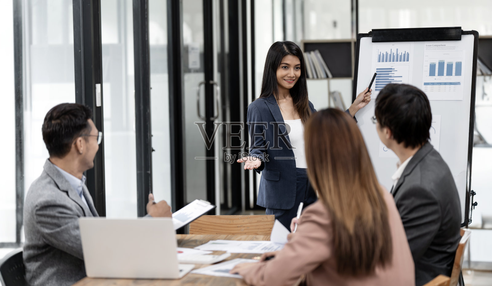 亚洲商务女性用财务或市场图表在黑板上展示，商务培训会议概念。照片摄影图片
