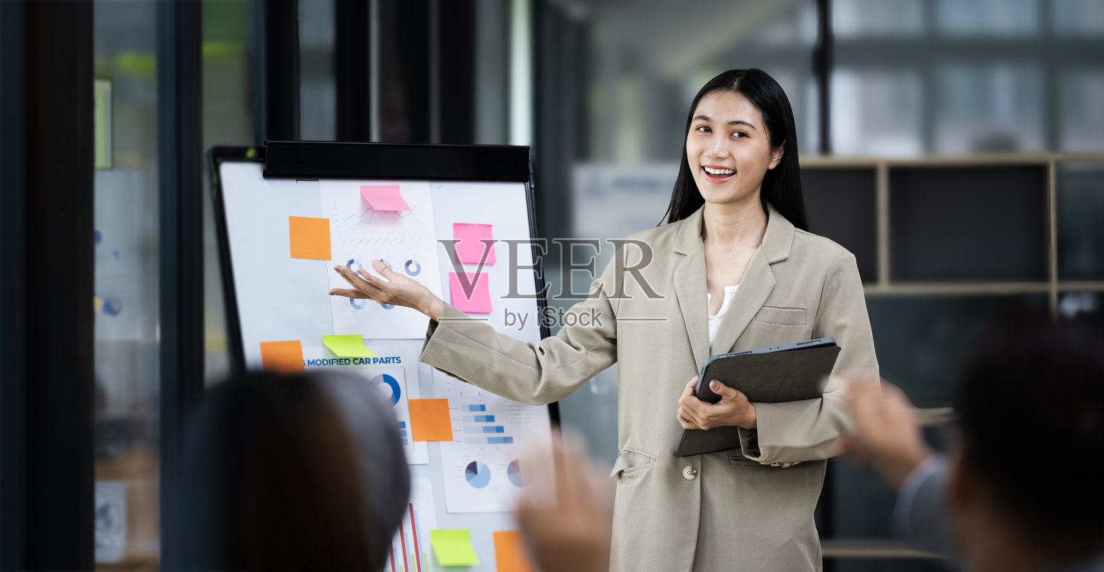 亚洲商务女性用财务或市场图表在黑板上展示，商务培训会议概念。照片摄影图片