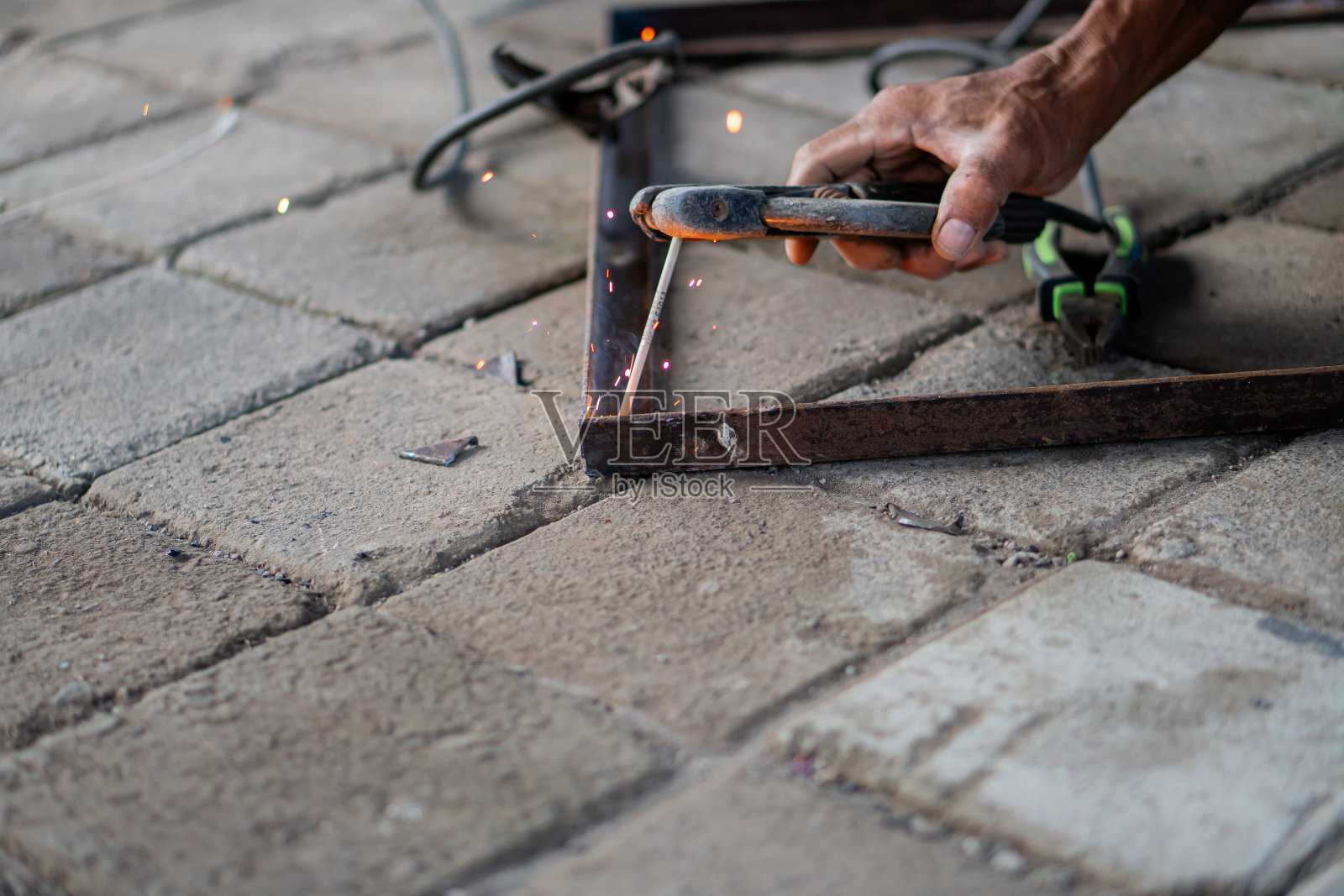 在铺设好的表面上焊接金属棒的特写照片摄影图片