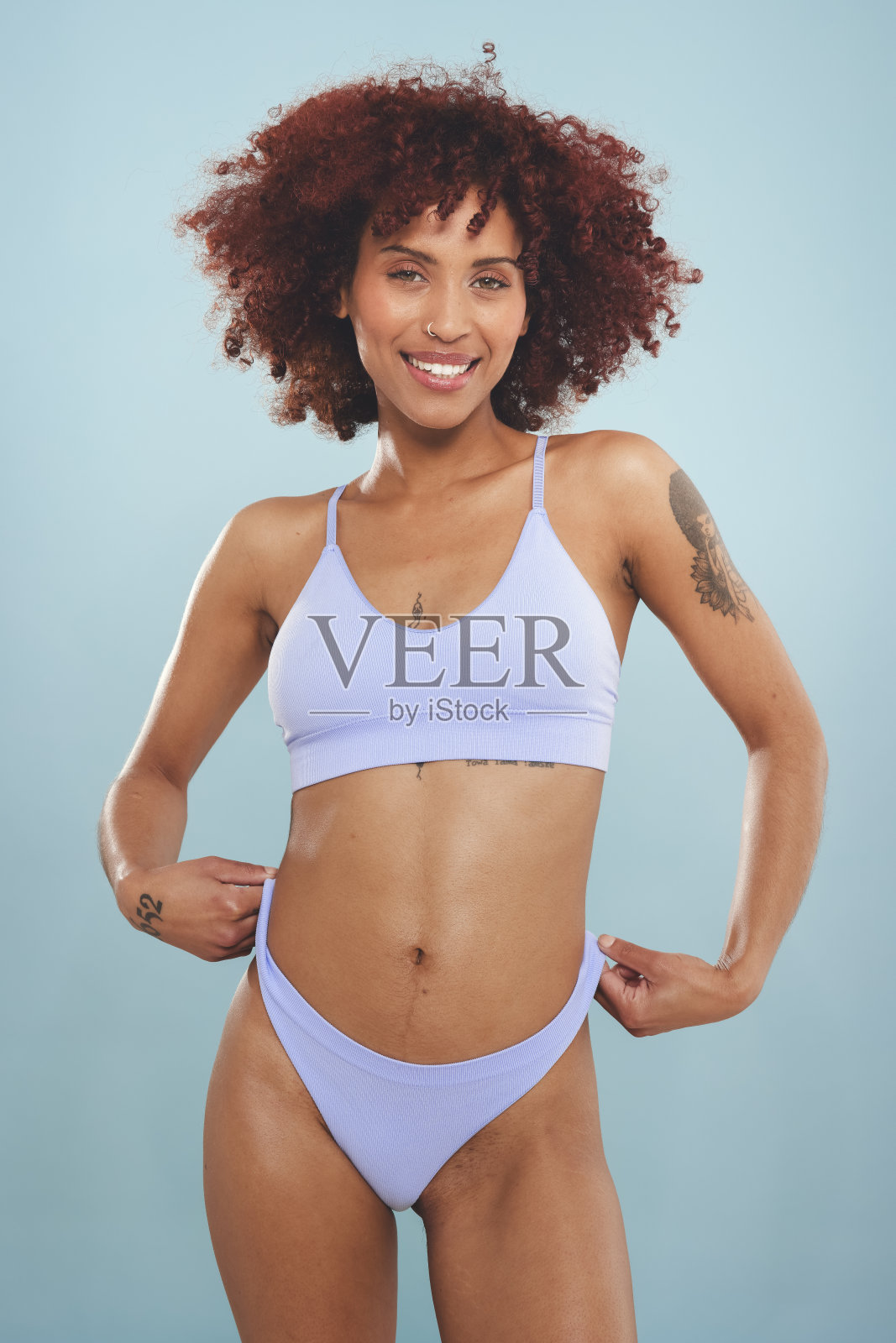 穿着内衣站在蓝色背景下的女人很开心照片摄影图片