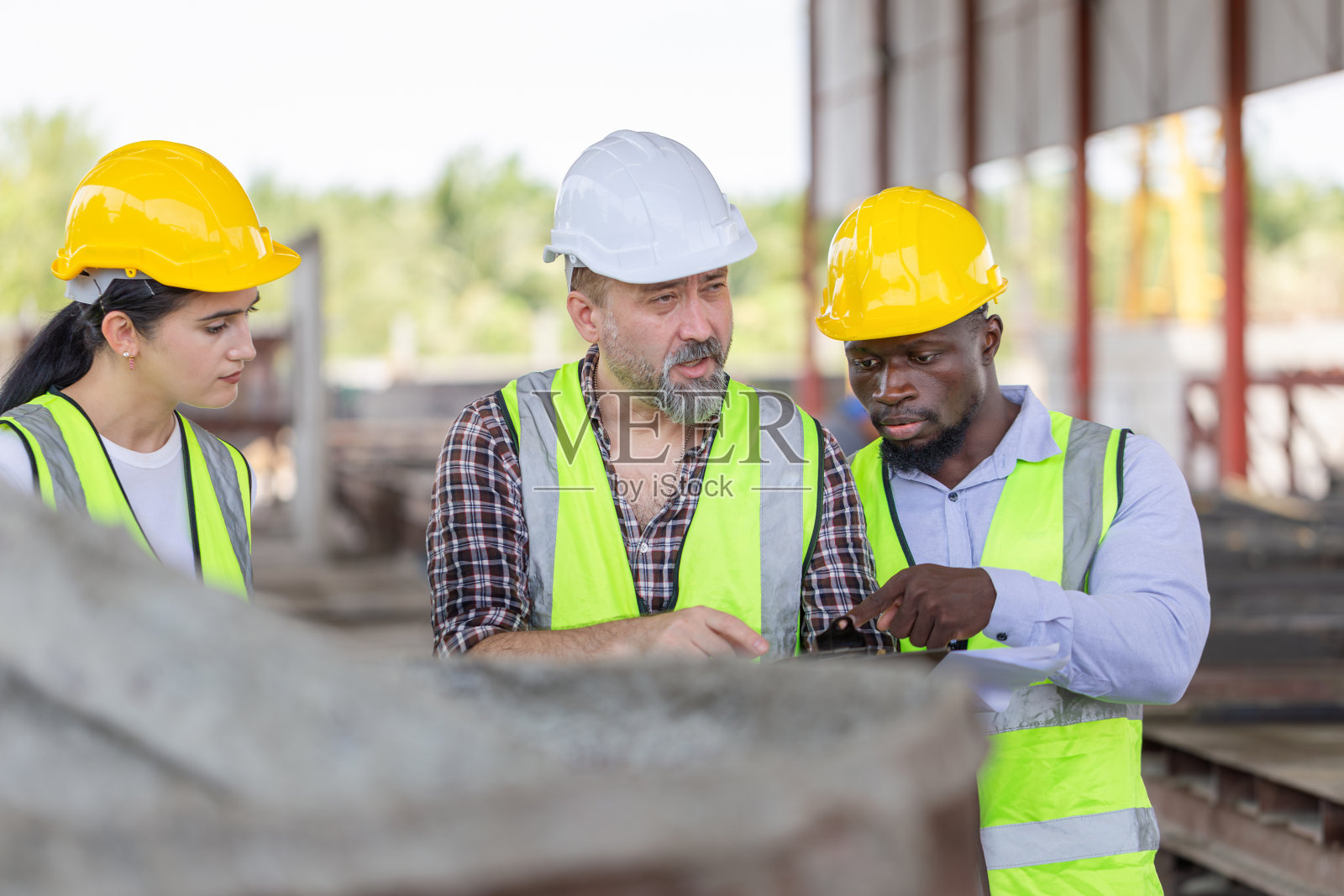工程师组和工头组在预制混凝土工厂现场检查工程，工程师和戴安全帽的工人在施工现场讨论照片摄影图片