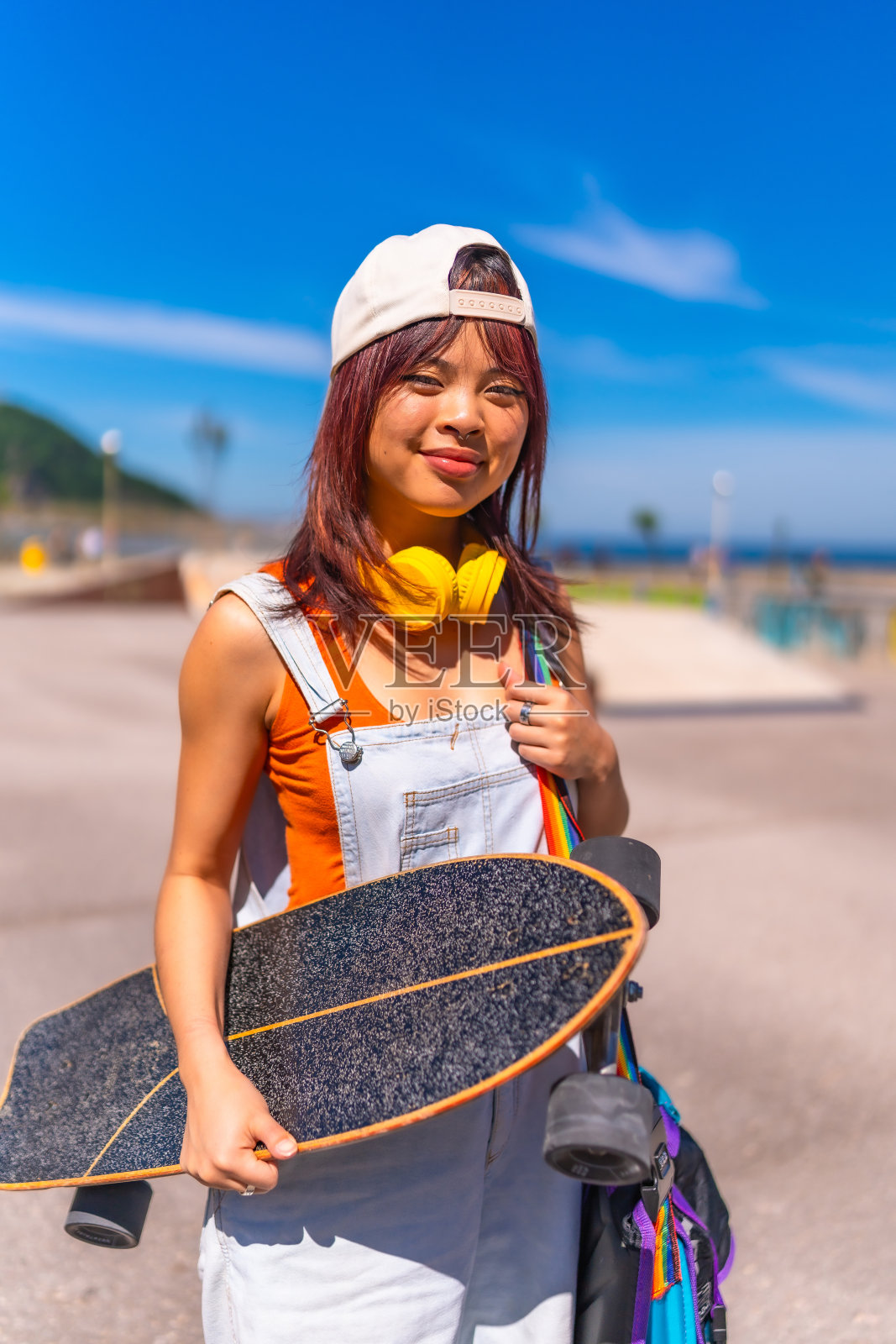 一个年轻的亚洲滑冰运动员在城市公园的肖像照片摄影图片