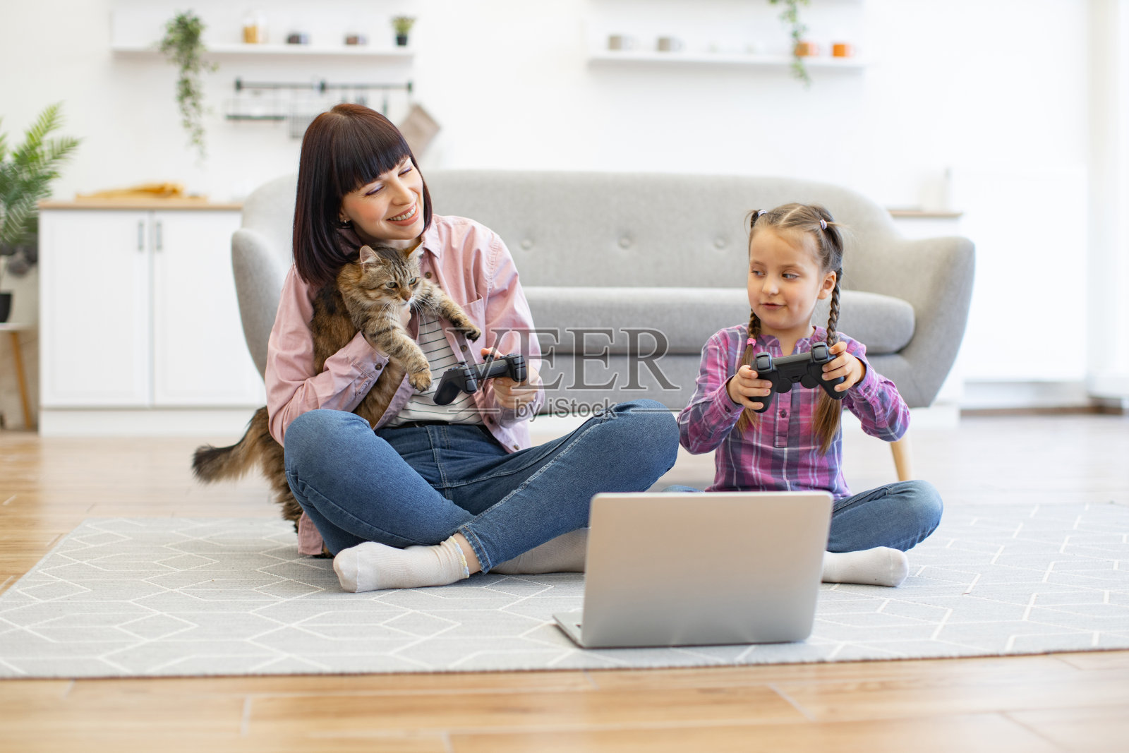 母女俩在地板上玩电子游戏照片摄影图片